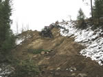 Removing the cut created by the guard on a steep side slope.