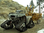 The track equipped ATV and self-loading log trailer are used to transport logs to the main landing for chipping and removal.