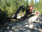 Placing logs and boulders to return channel to natural state.